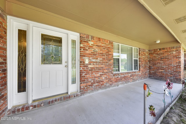 10870 High Ridge Rd, Jacksonville, FL 32225 - view of exterior entry with a porch, visible vents, and brick siding