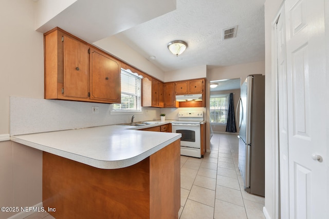 10870 High Ridge Rd, Jacksonville, FL 32225 - kitchen featuring freestanding refrigerator, a peninsula, visible vents, under cabinet range hood, and white electric stove