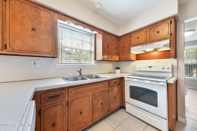 10870 High Ridge Rd, Jacksonville, FL 32225 - kitchen featuring white range with electric stovetop, a sink, light countertops, under cabinet range hood, and brown cabinetry