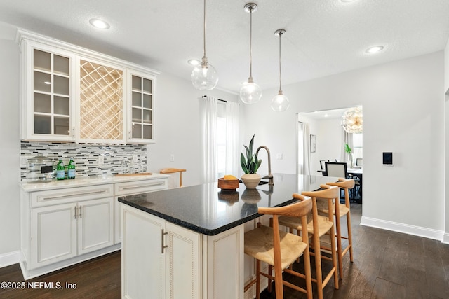 890 Beach Ave, Atlantic Beach, FL 32233 - kitchen with dark wood-style floors, backsplash, glass insert cabinets, and a breakfast bar