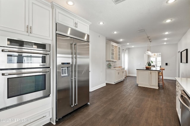 890 Beach Ave, Atlantic Beach, FL 32233 - kitchen with dark wood-style floors, white cabinetry, recessed lighting, stainless steel appliances, and decorative backsplash