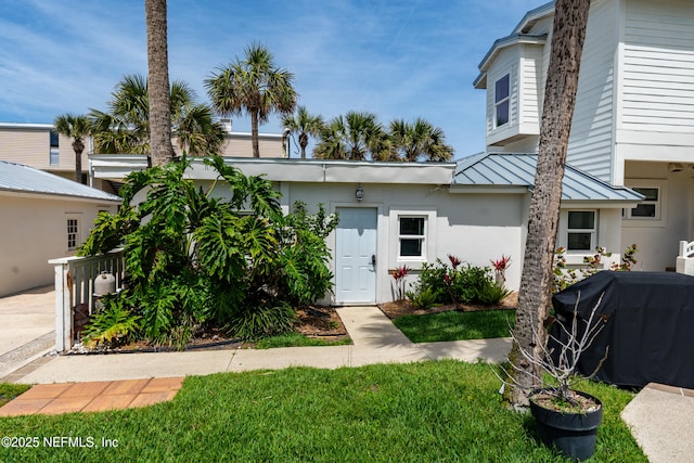 890 Beach Ave, Atlantic Beach, FL 32233 - view of front of house featuring a standing seam roof, stucco siding, metal roof, and a front yard