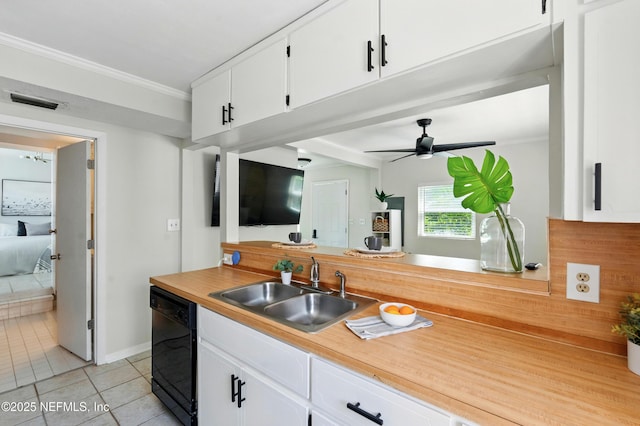 890 Beach Ave, Atlantic Beach, FL 32233 - kitchen with crown molding, light tile patterned floors, white cabinets, black dishwasher, and a sink