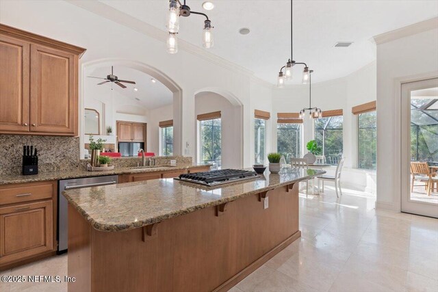 13648 Marsh Harbor Dr N, Jacksonville, FL 32225 - kitchen featuring backsplash, brown cabinetry, a kitchen bar, and stainless steel appliances