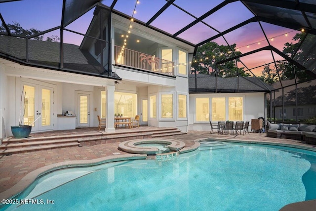 13648 Marsh Harbor Dr N, Jacksonville, FL 32225 - back of house at dusk featuring a patio area, an outdoor hangout area, stucco siding, french doors, and a balcony