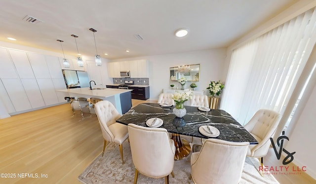 dining area with visible vents, light wood finished floors, and recessed lighting