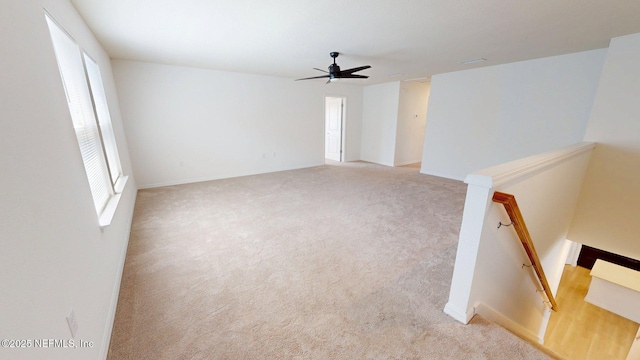 carpeted spare room featuring ceiling fan