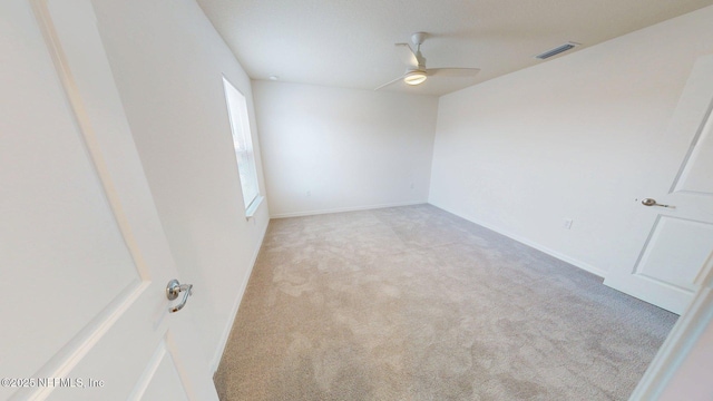 carpeted empty room featuring visible vents, baseboards, and a ceiling fan