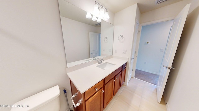bathroom featuring toilet, vanity, baseboards, and tile patterned flooring