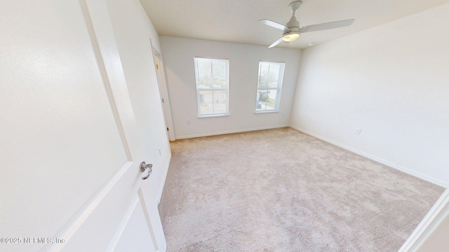 unfurnished room with baseboards, a ceiling fan, and carpet