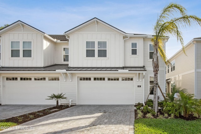 157 Oak Pk Dr, Saint Johns, FL 32259 - view of front facade featuring a garage, board and batten siding, decorative driveway, and a standing seam roof