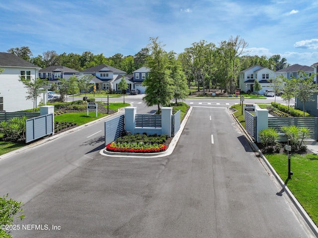 157 Oak Pk Dr, Saint Johns, FL 32259 - view of asphalt street with a residential view, curbs, traffic signs, and a gated entry