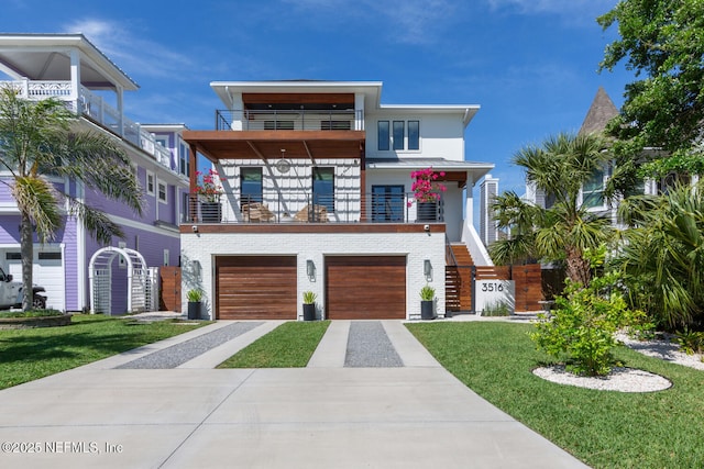 3516 1st St S, Jacksonville Beach, FL 32250 - modern home featuring a balcony, brick siding, a garage, concrete driveway, and a front lawn