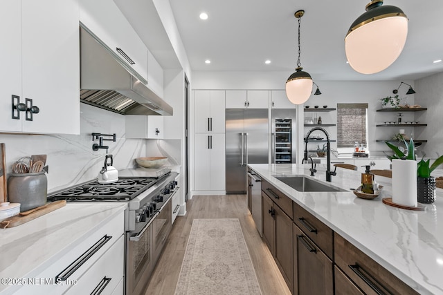 3516 1st St S, Jacksonville Beach, FL 32250 - kitchen with a sink, recessed lighting, under cabinet range hood, dark brown cabinetry, and high quality appliances