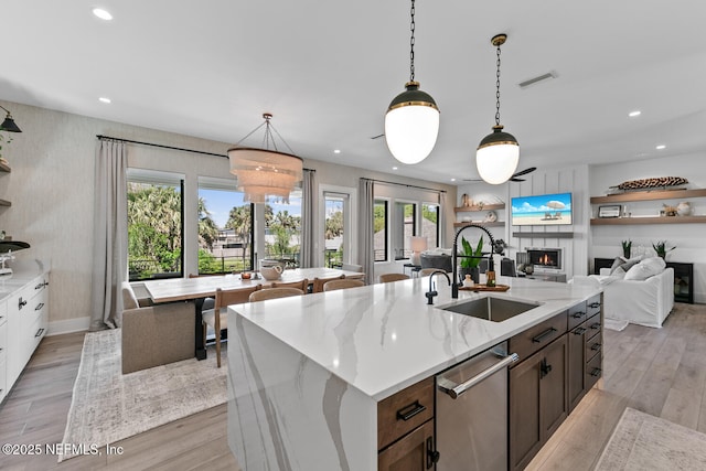 3516 1st St S, Jacksonville Beach, FL 32250 - kitchen with a sink, dishwasher, light wood-style floors, a warm lit fireplace, and recessed lighting