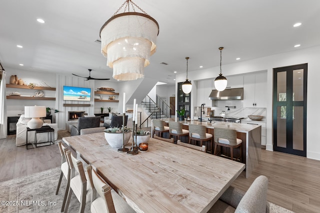 3516 1st St S, Jacksonville Beach, FL 32250 - dining space with a warm lit fireplace, recessed lighting, ceiling fan, stairway, and light wood-type flooring