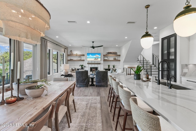 3516 1st St S, Jacksonville Beach, FL 32250 - dining space featuring light wood-style flooring, a lit fireplace, visible vents, stairway, and recessed lighting