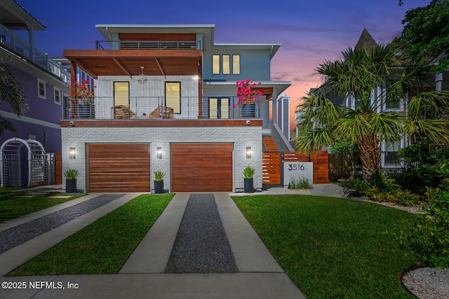 3516 1st St S, Jacksonville Beach, FL 32250 - contemporary home featuring an attached garage, brick siding, driveway, a balcony, and a front yard