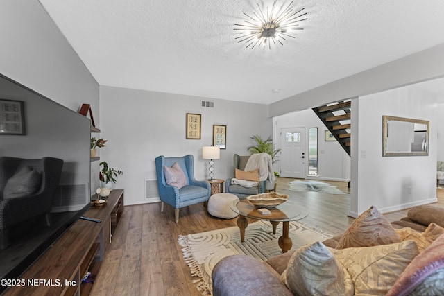 97282 Yorkshire Dr, Yulee, FL 32097 - living room with stairs, wood-type flooring, a textured ceiling, a chandelier, and baseboards