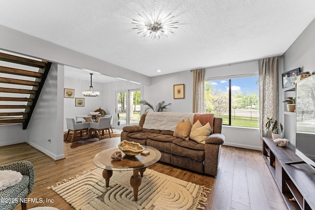 97282 Yorkshire Dr, Yulee, FL 32097 - living area with a chandelier, wood-type flooring, baseboards, a textured ceiling, and stairs