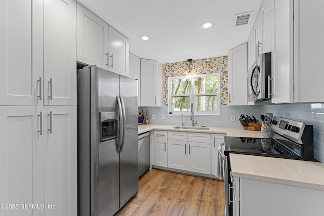 97282 Yorkshire Dr, Yulee, FL 32097 - kitchen with appliances with stainless steel finishes, a sink, tasteful backsplash, recessed lighting, and wood finished floors