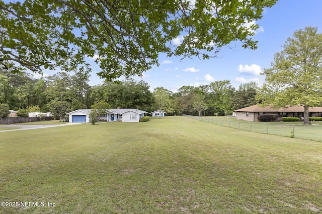 view of yard featuring a detached garage and fence