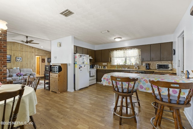 kitchen featuring light wood-type flooring, white appliances, visible vents, and dark brown cabinetry