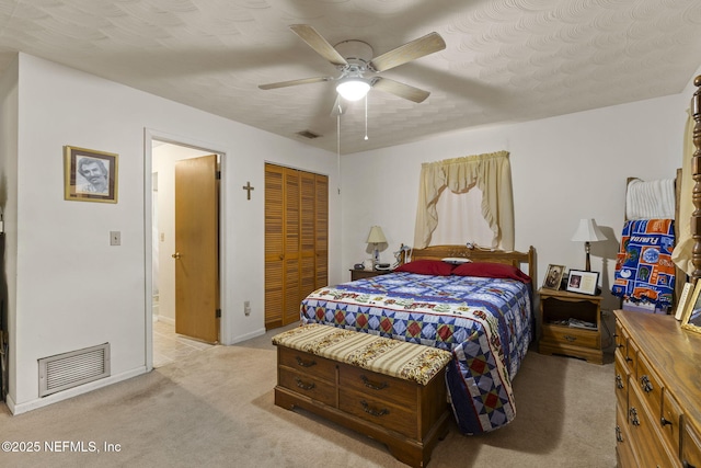bedroom featuring a closet, light colored carpet, a ceiling fan, and visible vents
