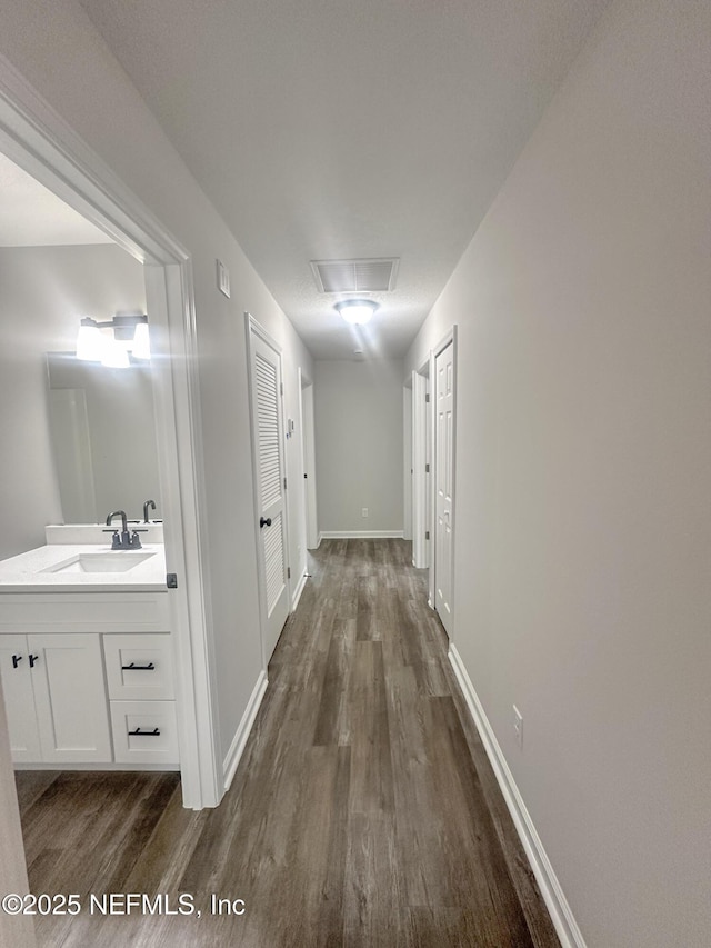 116 Moseley Ave, Palatka, FL 32177 - corridor featuring a sink, dark wood finished floors, baseboards, and attic access
