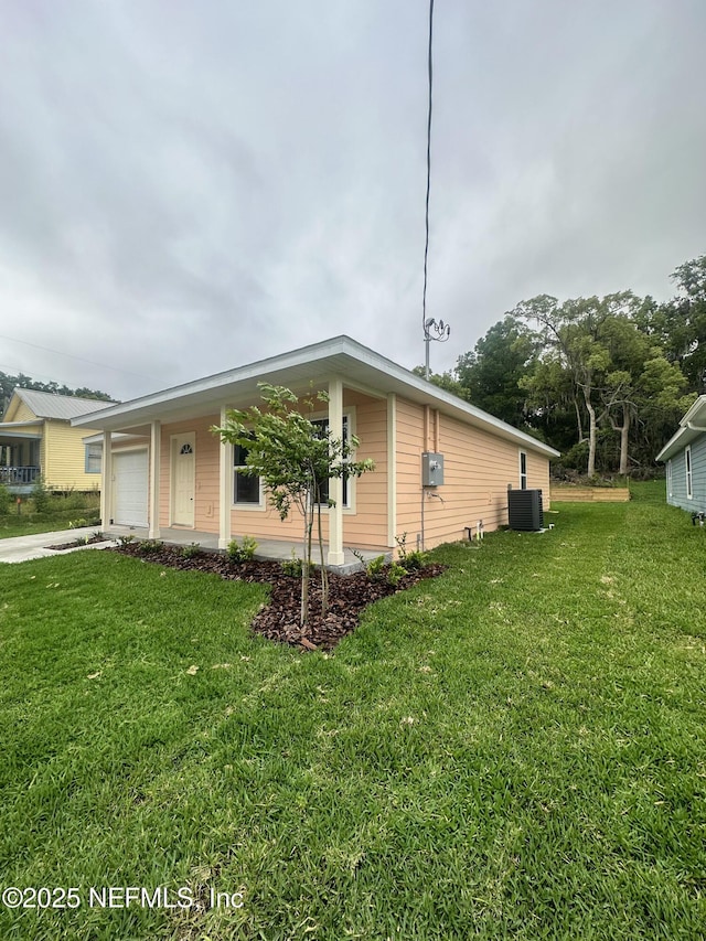 116 Moseley Ave, Palatka, FL 32177 - view of side of home featuring central AC, a yard, an attached garage, and concrete driveway