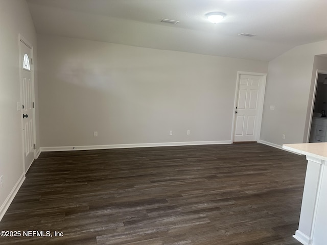 116 Moseley Ave, Palatka, FL 32177 - unfurnished living room with dark wood-style flooring, baseboards, and vaulted ceiling