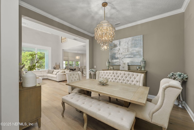 247 Vale Dr, Saint Augustine, FL 32095 - dining room with crown molding, a chandelier, and wood finished floors