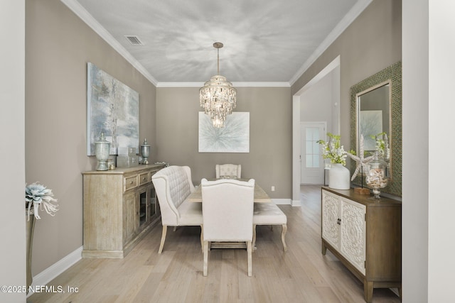 247 Vale Dr, Saint Augustine, FL 32095 - dining space with baseboards, light wood-style floors, a chandelier, and crown molding