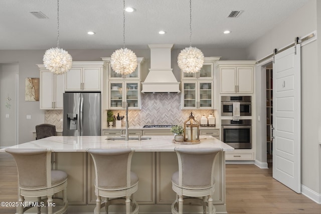 247 Vale Dr, Saint Augustine, FL 32095 - kitchen with premium range hood, visible vents, appliances with stainless steel finishes, and an inviting chandelier