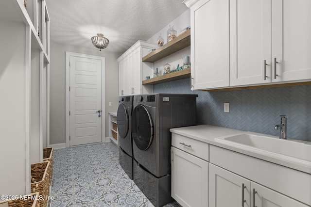 247 Vale Dr, Saint Augustine, FL 32095 - clothes washing area with washing machine and clothes dryer, tile patterned floors, a sink, a textured ceiling, and cabinet space