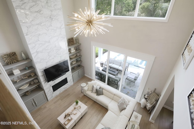 247 Vale Dr, Saint Augustine, FL 32095 - living room featuring a fireplace, a towering ceiling, and a notable chandelier