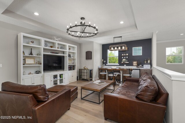 247 Vale Dr, Saint Augustine, FL 32095 - living room with light wood finished floors, a tray ceiling, recessed lighting, and a chandelier