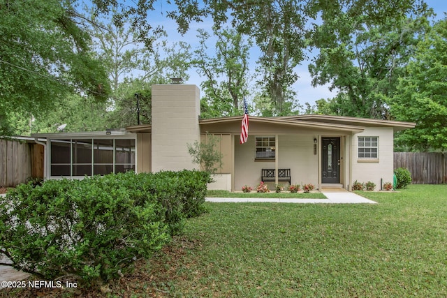 back of house with a sunroom, a yard, and fence