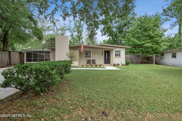 back of house with a yard, a sunroom, and fence private yard