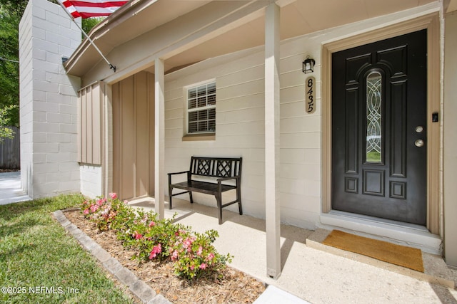 property entrance with a porch and concrete block siding