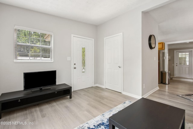 entryway featuring baseboards and wood finished floors