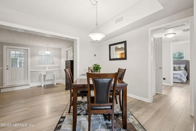 dining room featuring light wood-type flooring, baseboards, and visible vents