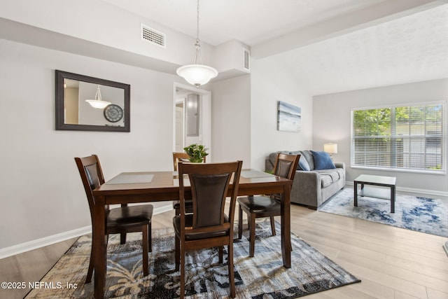 dining area featuring visible vents, baseboards, and wood finished floors