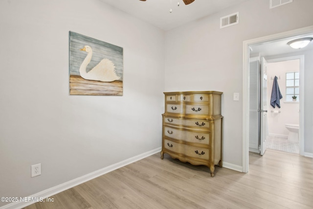 bedroom with visible vents, light wood-type flooring, baseboards, and ensuite bathroom