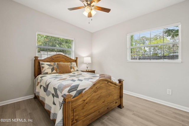 bedroom with light wood-type flooring, ceiling fan, and baseboards