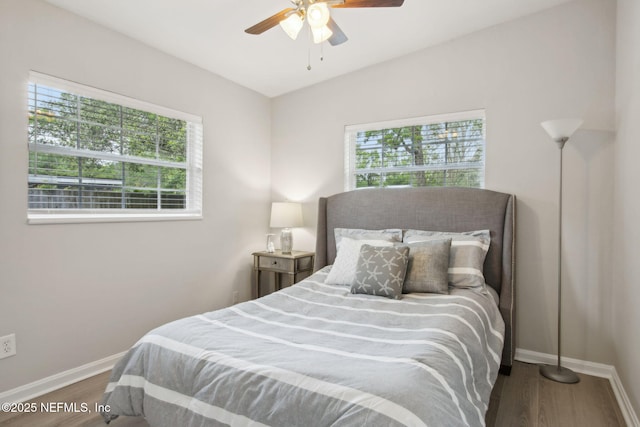 bedroom featuring lofted ceiling, ceiling fan, baseboards, and wood finished floors