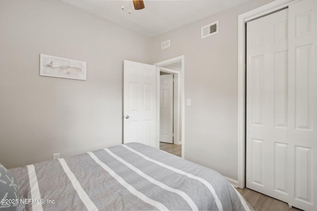 bedroom with visible vents, a closet, a ceiling fan, and light wood-style flooring