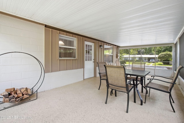 sunroom / solarium featuring outdoor dining area and a wealth of natural light