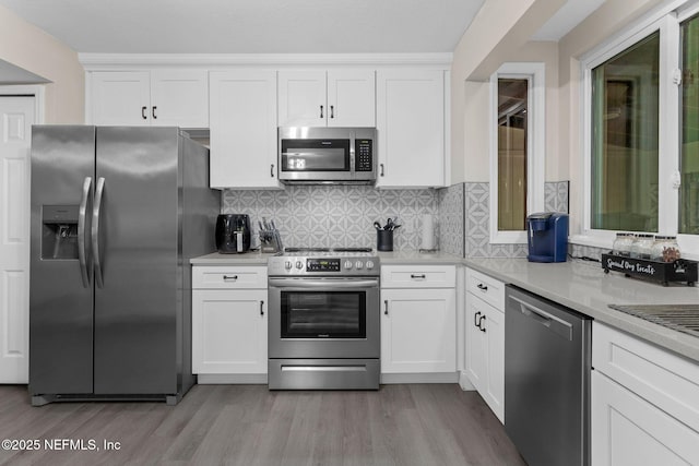 kitchen featuring light wood-style floors, appliances with stainless steel finishes, light countertops, and white cabinetry