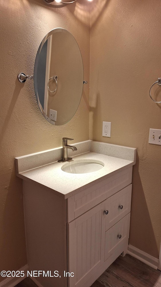 2756 Hidden Village Dr, Jacksonville, FL 32216 - bathroom featuring a textured wall, vanity, baseboards, and wood finished floors